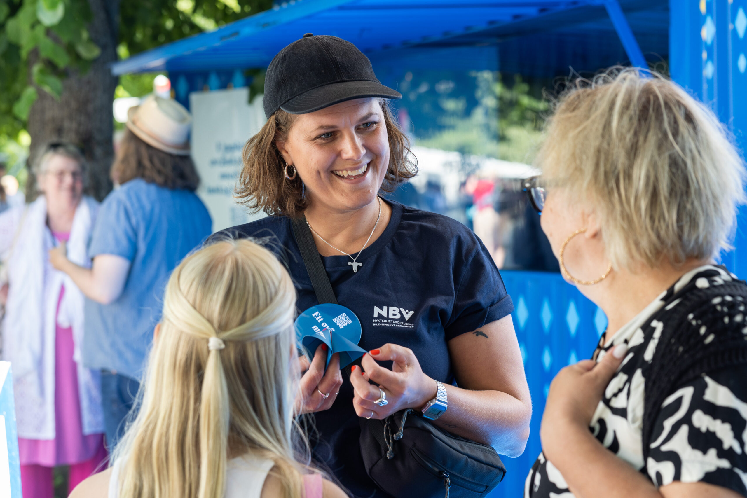 En NBV-medarbetare som ler mot en bes&ouml;kare under Almedalsveckan.