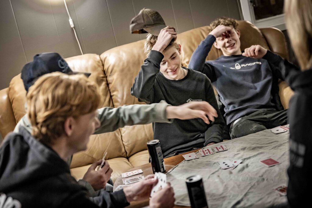 Ungdomar spelar kort i soffan